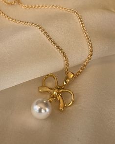 The Cosette Bow Necklace is dainty and sweet. Inspired by a vintage style and pairs well with matching earrings. 18kt gold plated silver bow and pearl the dangles. 22mm in length. Golf filled chain 16 or 18 inches. Pearl Bow, Bow Necklace, Bow Jewelry, Silver Bow, Elegant Accessories, Gold Plated Silver, Matching Earrings, Vintage Style, Gold Necklace