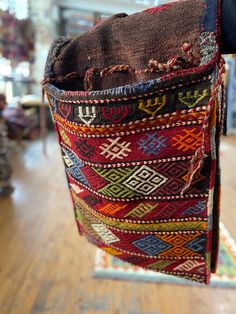 the inside of a bag is made from old rugs and other colorful items on display