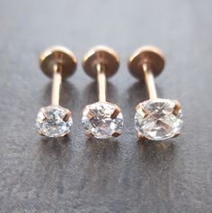 three pairs of diamond studs on a table