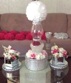 a glass table topped with flowers and vases on top of it's sides