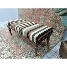 a striped bench sitting on top of a rug