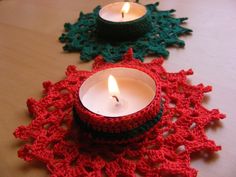 crocheted doily with two lit candles on it