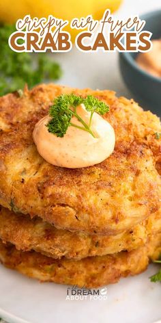 crab cakes are stacked on top of each other with a small dollop of mayonnaise