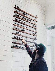 a man writing on a wall with wooden signs