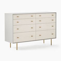 a white dresser with gold handles and drawers on it's sides, against a white background