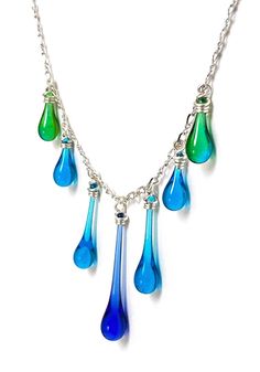 Seven handmade glass droplets drip from a twisted chain of sparkling silver in this exquisite necklace design. Colors vary - you are welcome to request a color palette. Droplet lengths: 3/4" - 1 1/4" (1.9 - 3.2 cm) Chain length: 16" to 18.5" - a 16" recycled sterling silver twist chain with 2.5" inch extender allows adjustment to fit your style and outfit Eco−friendly jewelry, made from sun−melted recycled bottles and stained glass, finished with recycled silver Recycled sterling silver findings Elegant Glass Drop Jewelry, Elegant Drop Glass Jewelry, Elegant Drop-shaped Glass Jewelry, Party Drop Necklace With Adjustable Chain, Teardrop Adjustable Chain Necklace For Party, Teardrop Necklace With Adjustable Chain For Party, Teardrop Party Necklace With Adjustable Chain, Silver Czech Glass Dangle Necklaces, Silver Dangle Necklace With Czech Glass