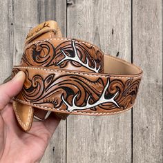 a handmade leather belt with deer antlers on it