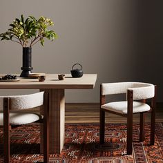 a table with two chairs and a potted plant