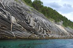 the rock formation is very interesting and unique to see in this photo, it looks like an ocean cliff