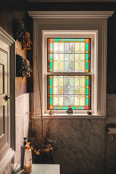 a bathroom with a sink, toilet and stained glass window