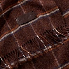 a brown and blue plaid coat with a leather tag on it's lapel