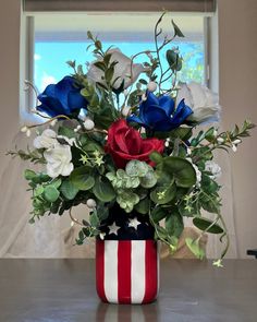 a patriotic flower arrangement in a red, white and blue vase