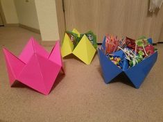 three origami bowls with candy in them