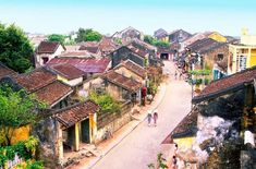 an aerial view of a city with old buildings and people walking down the street in front of them