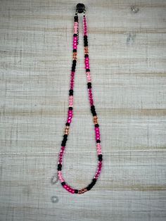 This hand-beaded necklace is an excellent addition to any outfit. Perfect for rodeos and other events that have a "pink night." It is made with elastic and includes an extension chain to be able to fit most necks comfortably. I can adjust the length if needed as well.  *This necklace is handmade with care. Some materials are more fragile than others. I make every effort to ensure durability, but please make sure to treat your jewelry with special care (like taking it off before showers).* *Pleas Pink Beaded Necklaces For Festivals, Hand-strung Pink Jewelry For Festivals, Pink Hand-strung Jewelry For Festival, Adjustable Pink Beaded Necklaces With Colorful Beads, Adjustable Pink Beaded Necklace, Pink Jewelry With Adjustable Black Beads, Festival Pink Beaded Necklace, Festival Hand-strung Pink Beaded Necklaces, Pink Hand-strung Beaded Necklaces For Festival