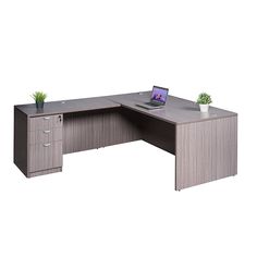 an office desk with a laptop on it and a plant in the corner next to it