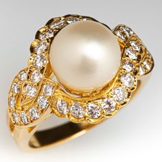 This impressive ring is centered with one (1), post set, cultured saltwater pearl. The ring is also accented with thirty-four (34), bead set, round brilliant cut diamonds. The ring measures 14.4mm at the top, rises 10.8mm above the finger, tapering to 2.5mm wide and 1.2mm thick at the base of the shank. This ring is currently a size 4.75. Pearl Diamond Ring, Saltwater Pearls, Pearl And Diamond Ring, Bead Set, Pearl Diamond, Brilliant Diamond, Gold Pearl, Round Brilliant Cut Diamond, High Quality Jewelry