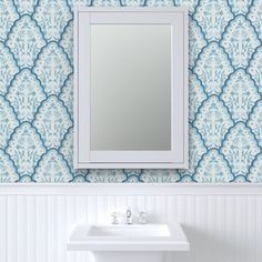 a white sink sitting under a bathroom mirror next to a wall mounted faucet