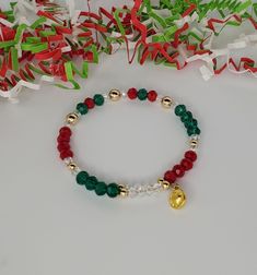 "Classic Christmas colors adorn this holiday bracelet of green and red glass crystal beads, accented with glimmering clear glass crystal beads and 14K gold-filled balls, and a 14k gold-filled heart charm. Give this Christmas gift to a special someone. Made with antique brass memory wire, these bracelets wrap simply and gently around your wrist - no clasp required. And they fit most sizes comfortably. Wear as a stand-alone piece or stack with other Christmas Holiday Group bracelets for a festive Cheap Beaded Bracelets For Holiday, Cheap Holiday Beaded Bracelets For Gift, Red And Green Jewelry, Christmas Diy Jewelry, Group Bracelets, Christmas Beaded Jewelry, Christmas Beaded Bracelets, Christmas Bracelet Ideas, Holiday Bracelet