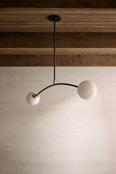 three light fixtures hanging from the ceiling in a room with wood paneling and white walls