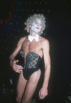 a man in a corset with white makeup on his face