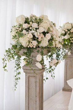 two vases filled with white flowers on top of a table