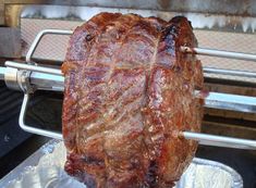 a large piece of meat sitting on top of a grill