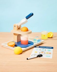 a wooden toy set with an orange and some other items on it, including a pen