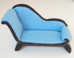 a crocheted blue and brown chair sitting on top of a white table