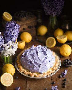 there is a cake on the table with lemons and blueberries