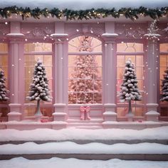 a pink christmas window display with snow on the ground and trees in front of it