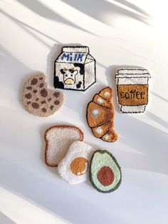 four pieces of crocheted bread and two cups of coffee on a white surface