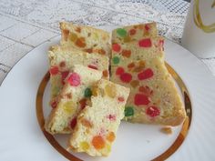 several pieces of cake on a plate with a cup and saucer in the background