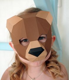 a girl wearing a paper mask with a bear on it's face and eyes