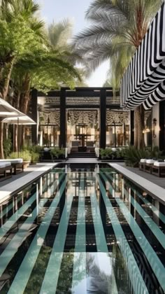 an outdoor swimming pool surrounded by palm trees