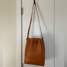 Genuine Leather Mansur Gavriel Bucket Bag In Color Cammello With Raw Leather Interior. Interior Zipper Pouch Included. Some Surface Scratches. Yellow Leather Crossbody Bucket Bag, Mansur Gavriel Soft Candy Bag, Mansur Gavriel M Frame Bag, Mansur Gavriel Mini Mini Bucket Bag, Mansur Gavriel Bucket Bag, Mansur Gavriel Bag, Raw Color, Raw Leather, Mansur Gavriel