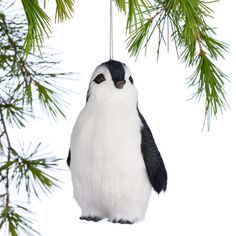 a penguin ornament hanging from a pine tree