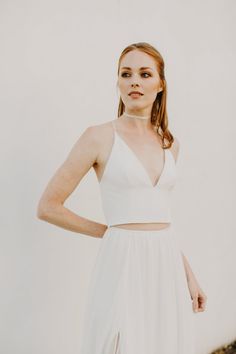 a woman in a white dress poses with her hands on her hips