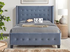 a bed with blue upholstered headboard and foot board