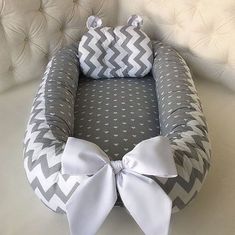 a gray and white baby bed with a bow on it