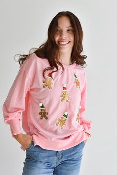 Deck the halls with this festive holiday Sequin Gingerbread Man Shirt. Adorned with colorful sequin gingerbread men, this classic pink pullover shirt is perfect for those cozy winter days and nights. Pair with jeans for daytime or a sequin skirt for a holiday gift exchange. FIT: Fits true to size. We recommend taking your normal size. MATERIAL: 95% Cotton, 5% Polyester. SIZE GUIDE: S (2-4) / M (6-8) / L (10-12) MODEL DETAILS: Our model Karlie (photos) is 5'7 and wearing a size S. Karlie's measur Festive Pink Crew Neck Top, Pink Holiday Festive Tops, Pink Holiday Festive Top, Pink Holiday Tops For Festive Occasion, Pink Long Sleeve Festive Tops, Pink Long Sleeve Tops For Festive Occasions, Pink Festive Winter Top, Holiday Pink Long Sleeve Tops, Pink Long Sleeve Holiday Top