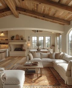 a living room filled with white furniture and lots of wooden beams on the ceiling,