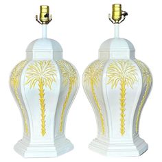 two white and gold vases with palm trees on them