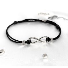 Personalized Infinity String Bracelet for Men and Boys will complete any outfit in any style. The Bracelet is perfect for women and men; For boys and girls. This Infinity Bracelet will be your favorite string Bracelet. Great minimalist gift for him! You can personalize Infinity String Bracelet with one silver-colored initial charm. Choose from A to Z.    Bracelets are waterproof and designed for daily wear. Specifications: The adult-size Bracelet is adjustable from 6 - 8 inches. The Adult Plus size Bracelet is adjustable from 8 - 11 inches. The child-size Bracelet is adjustable from 4.5 - 6 inches. I use a very soft Satin Nylon Cord and stainless steel or silver-plated beads for Bracelet. The cord is remarkably soft with a smooth surface, durable, and most important - waterproof. It is so Black Adjustable Infinity Jewelry, Adjustable Infinity Friendship Bracelets, Casual Silver Infinity Jewelry, Adjustable Infinity Bracelet, Black Infinity Bracelet For Friendship, Black Infinity Friendship Bracelet, Infinity Anklet, Eternity Bracelet, Couples Bracelet