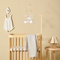 a baby's crib with a lamp and stuffed animals hanging from the wall