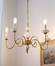 a chandelier with five lights hanging from it's sides in a room