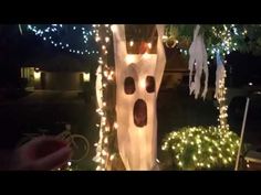 there is a fake ghost in the yard with christmas lights on it's trees