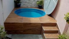 a small pool with steps leading up to it and a mirror on the wall above