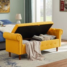 a bedroom with a bed, couch and ottoman in yellow upholstered fabric on the floor