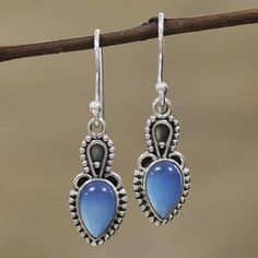 Considered by some to absorb negative energy, cool blue chalcedony is intriguing in these earrings from Alok Jain. Artisans set the cabochon gems in sterling silver bezels and surround them with silver rawa or granules. Contrasting oxidization adds interest to the unique earring design. The earrings swing from sterling silver hooks. Blue Cabochon Moonstone Jewelry, Chalcedony Dangle Jewelry With Matching Earrings, Chalcedony Dangle Earrings With Matching Jewelry, Teardrop Blue Moonstone Jewelry, Blue Teardrop Moonstone Jewelry, Blue Drop Jewelry With Cabochon, Blue Cabochon Drop Jewelry, Blue Drop Cabochon Jewelry, Chalcedony Dangle Jewelry Gift